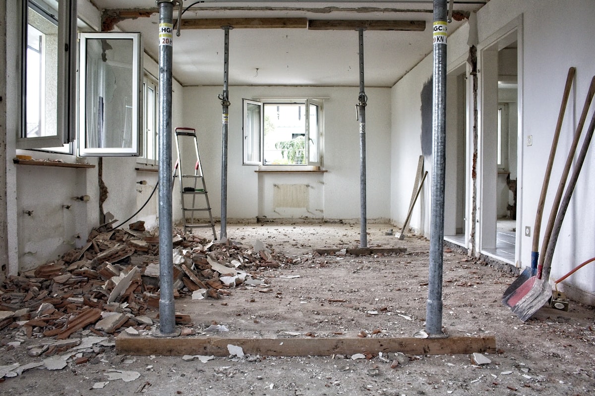 Woning in de strip-out: losse kozijnen, een binnendeurkozijn en puin op de vloer